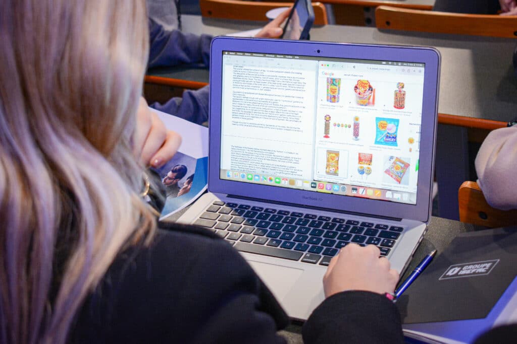 Une jeune femme blonde regarde un écran d'ordinateur