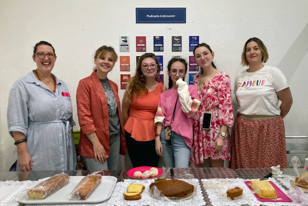 6 jeunes femmes tiennent un stand de gâteaux pour récolter des dons pour Octobre Rose